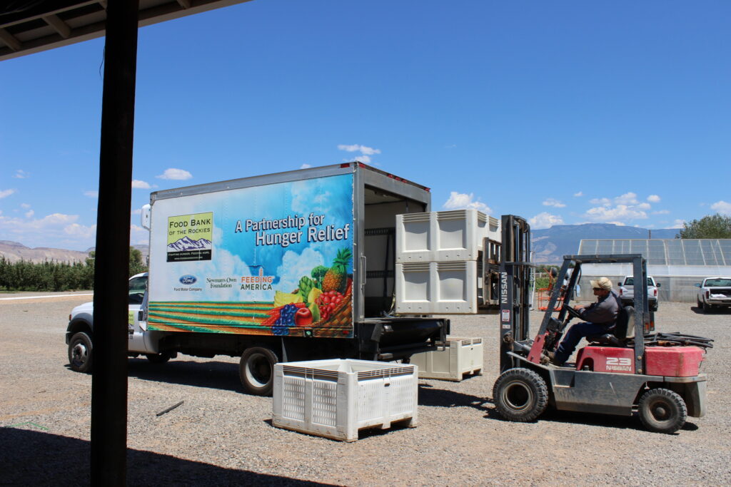 forklift loading fruit crates into Food Bank of the Rockies box truck
